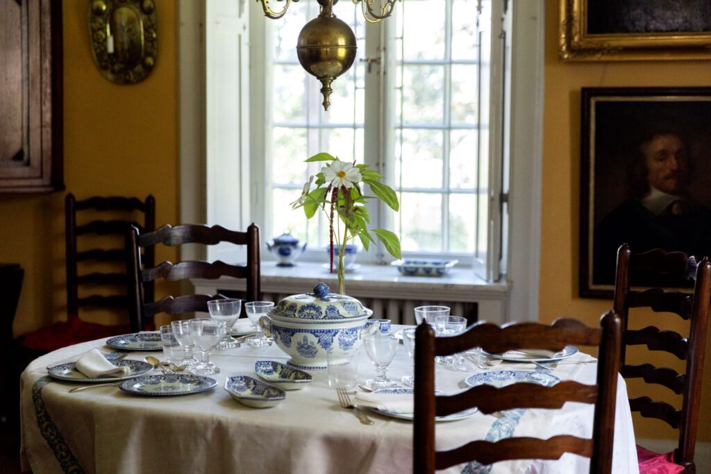 Ett elegant dukat bord med blåvitt porslin i en historisk matsal.